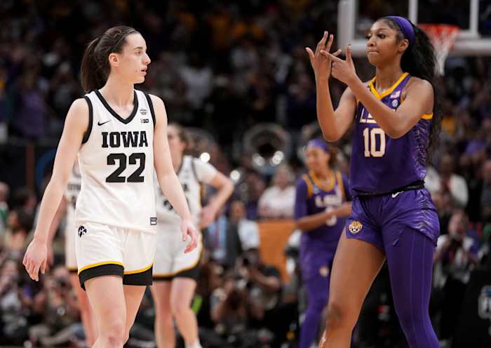 LSU forward Angel Reese (10) shows Iowa guard Caitlin Clark (22) her ring finger